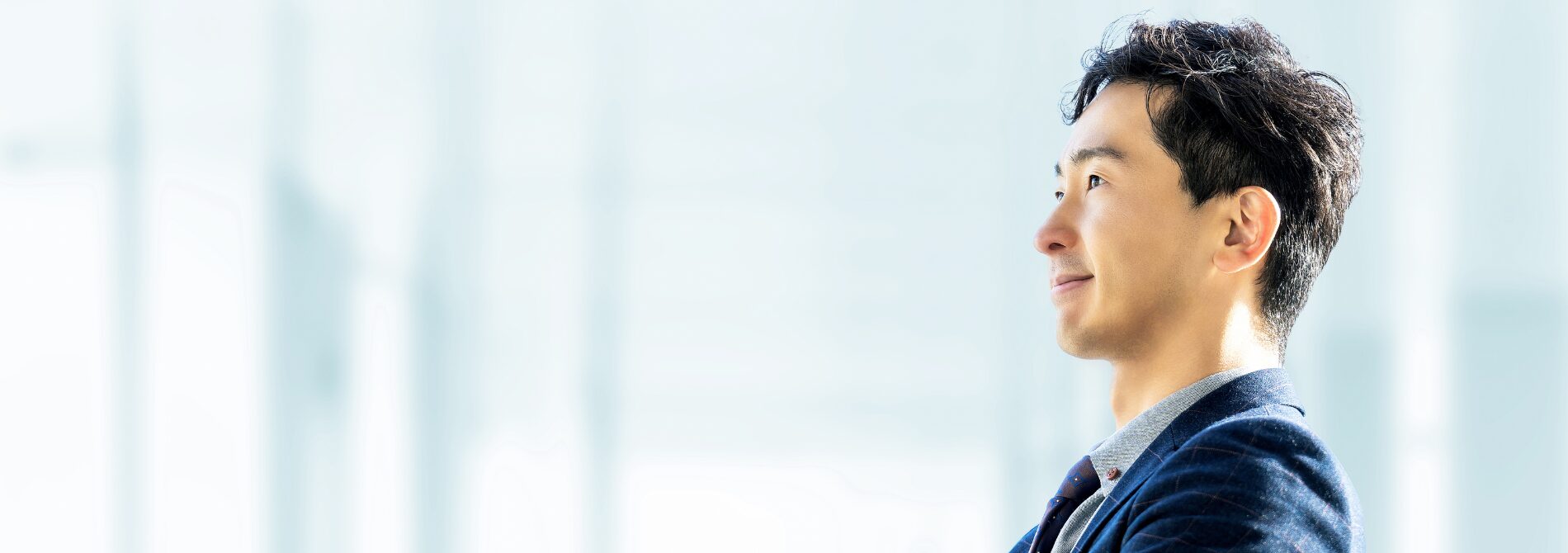 希望を持った表情で遠くを見つめる男性の写真